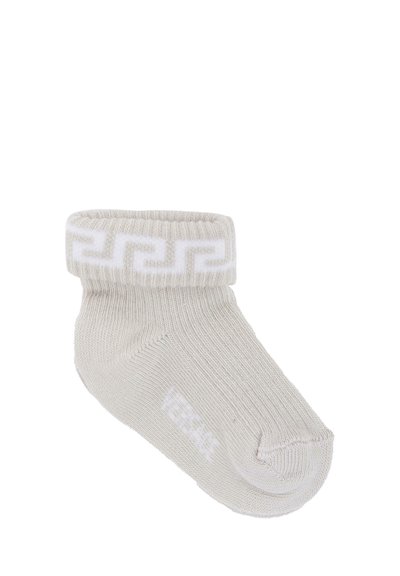 Calza alla caviglia grigio chiaro con una texture a coste, con un motivo geometrico bianco sul risvolto e un piccolo logo bianco vicino alla punta.