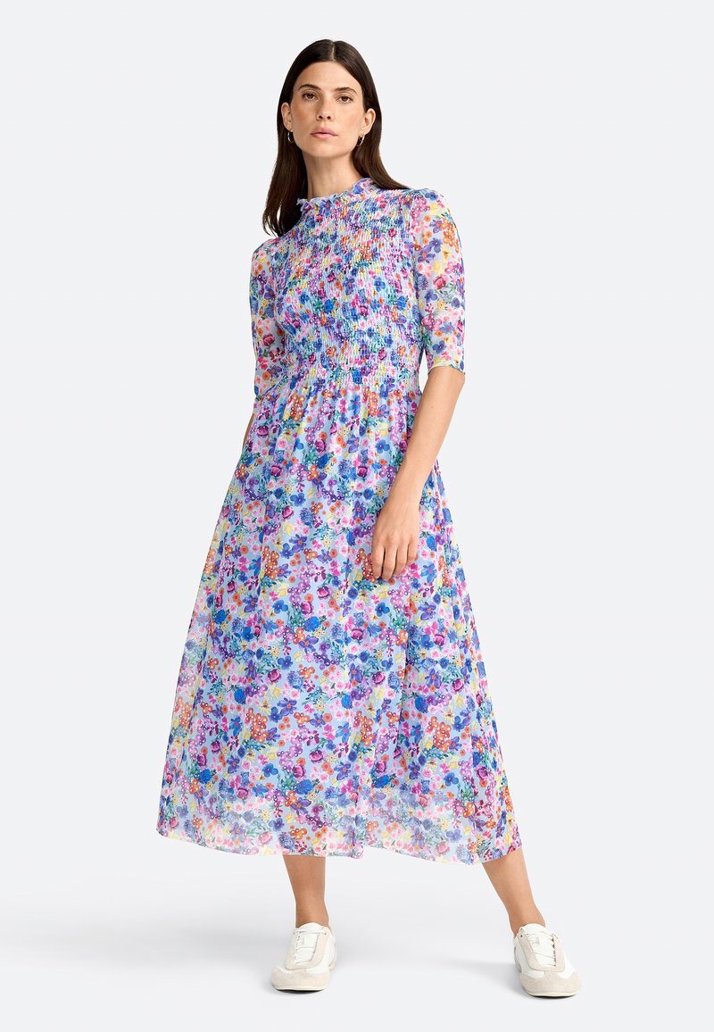 Florales Maxikleid aus leichtem, durchscheinendem Stoff. Verfügt über ein smocktes Oberteil, kurze Ärmel und eine Mischung aus blauen, rosa und orangen Blumen.