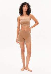 Haut bandeau et short mi-cuisse en tissu côtelé marron clair, design ajusté avec bandes élastiques, bords sans coutures et texture douce.