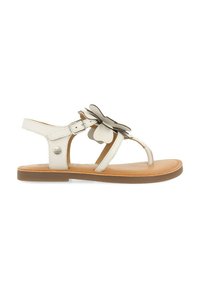 Sandalia de cuero blanca con un acento floral, correa ajustable en el tobillo y suela plana marrón. Presenta un diseño minimalista y una textura suave.