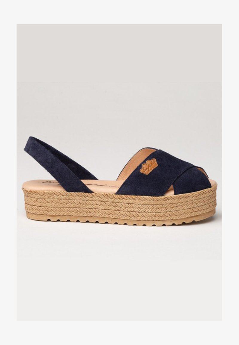 Sandalia cuña de ante azul marino con punta abierta, diseño entrelazado, suela de yute trenzado y detalles en cuero con logotipo.