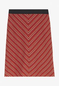 Jupe à motifs zigzag rouge et marine avec une ceinture noire, fabriquée en tissu texturé, présentant une coupe droite.