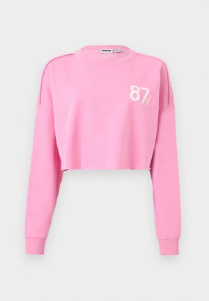 Pink cropped sweatshirt med lange ærmer og ribkantede manchetter, med nummeret "87" og en lille logo på øverste venstre bryst.