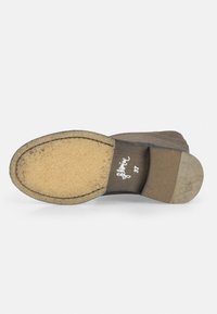 Suela de zapato de gamuza marrón con una suela de goma texturizada, tacón curvado y un logo manuscrito con el tamaño 37 grabado en la parte inferior.
