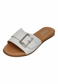 White slide sandal with wide strap featuring a silver rectangular buckle. Brown textured insole and flat, tan outsole.