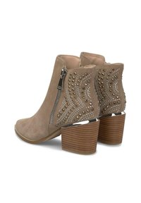 Botas de tobillo de ante topo con cremalleras laterales, tacones de madera apilados y tachuelas decorativas en plata y oro con patrones ondulados en los costados traseros.