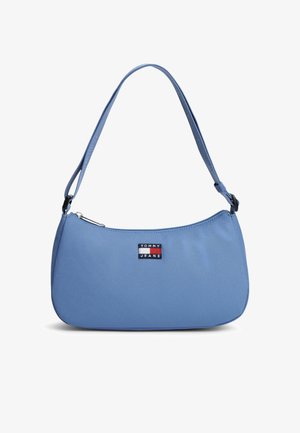 Lyseblå Tommy Jeans skuldertaske med justerbar strop og frontlogo patch i rød, hvid og blå, lynlås lukning øverst.