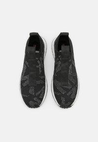 Czarne dzianinowe sneakersy z teksturowanym wzorem, z kontrastowym paskiem i białą podeszwą. Projekt jest elegancki i zakładany na stopę.