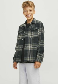 Svart och grå rutmönstrad skjortjacka i mjukt material, med två bröstfickor, tryckknappar och en avslappnad passform.