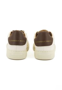 Sneakers bianchi in pelle con un tallone in pelle marrone. "ALEXANDER SMITH" impresso in oro sul tallone e sul lato. Suola in gomma.