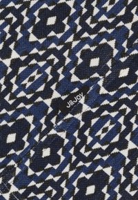 Gestructureerde stof in marineblauw, wit en zwart geometrisch patroon met bloemmotieven. Bevat een zwart label met het logo "J&JOY".