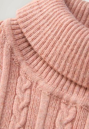 Pull en tricot texturé de couleur rose doux avec un col roulé côtelé et un motif en torsades sur le devant, mettant en valeur différentes techniques de tricot.