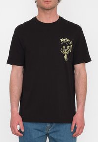 Zwarte katoenen t-shirt met korte mouwen, ronde halslijn en een gele grafische logo op de linkerborst, voorzien van tekst en een designelement.
