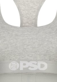 Sostén deportivo gris con una textura suave, diseño de espalda nadadora y una banda ancha con el logo "PSD" en blanco. Detalles cosidos a lo largo de los bordes.