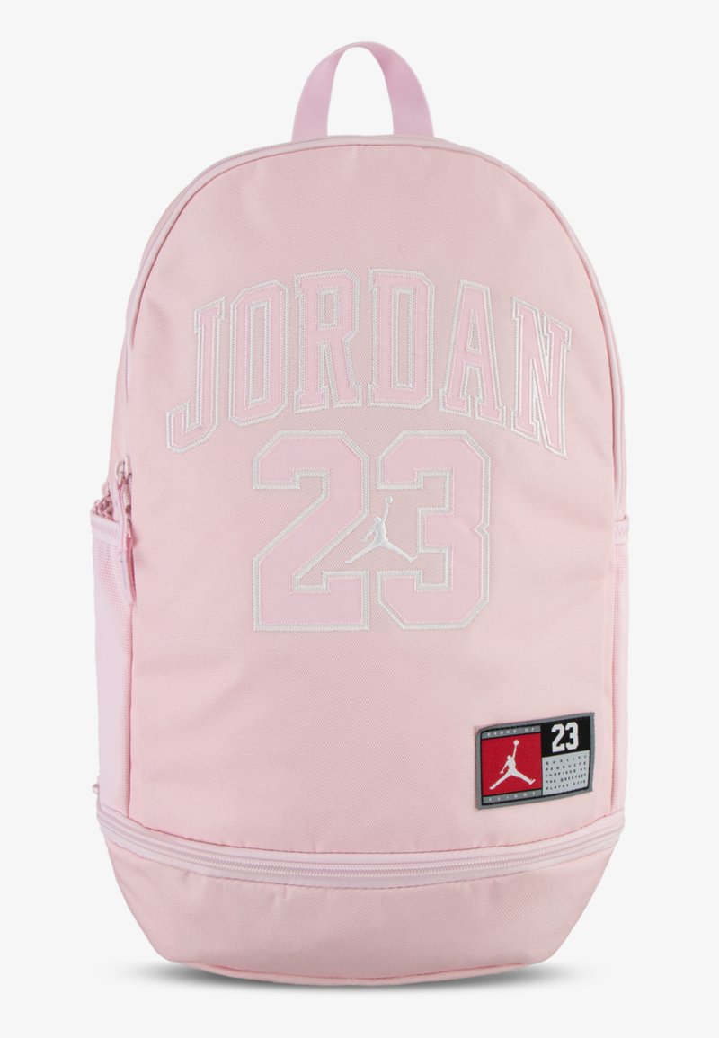 Rosa stoffryggsekk med "JORDAN" og "23" i hvit brodering, et logo-patch og en glidelåslomme nederst.