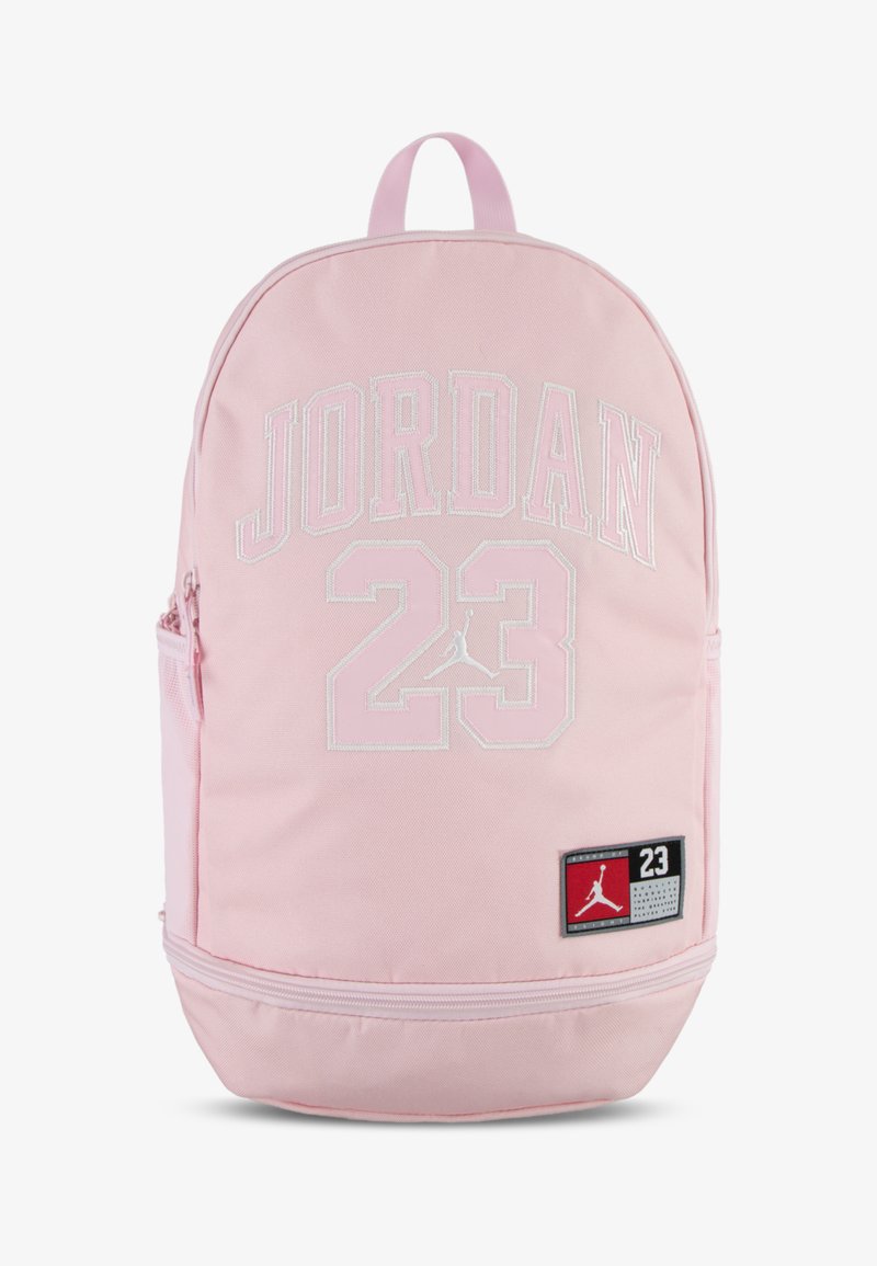 Mochila de tecido rosa com "JORDAN" e "23" em bordado branco, um patch com o logótipo e um compartimento com fecho na parte inferior.