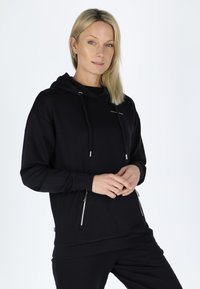 Black hoodie with a relaxed fit, featuring a drawstring and two zippered side pockets. Smooth texture with silver accents.