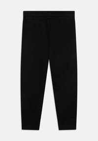 Schwarze Jogginghose aus weichem Material, mit elastischem Bund und gerippten Bündchen. Sie hat ein schlichtes, tailliertes Design ohne Muster oder zusätzliche Details.