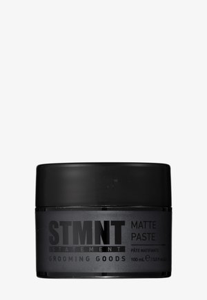 Prodotto per lo styling dei capelli STMNT matte paste in un contenitore nero da 100 ml con tappo a vite.