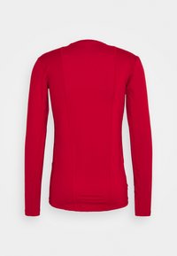 Rotes Langarmshirt mit Rundhalsausschnitt, glatter Textur und tailliertem Design. Verfügt über vertikale Nähte auf der Rückseite für zusätzliche Struktur.