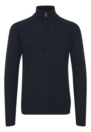 Pull-over zippé bleu marine avec col haut, motif tricot texturé, poignets et ourlet côtelés, et coupe slim.