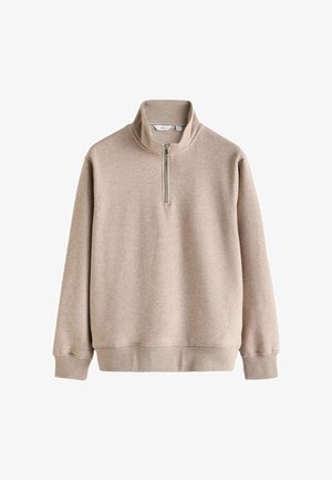 Sudadera de color beige con cremallera de cuarto hecha de una tela suave y texturizada. Cuenta con mangas largas y un dobladillo acanalado, con una cremallera plateada en el cuello.