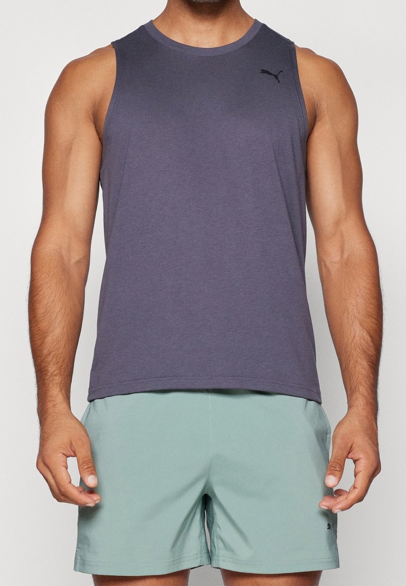 Débardeur de sport sans manches en tissu doux de couleur violette, avec un col rond et un logo noir subtil en haut à gauche.