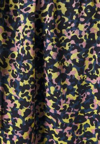 Tela multicolorida con un patrón abstracto de leopardo en negro, rosa, amarillo y azul sobre un fondo texturizado.