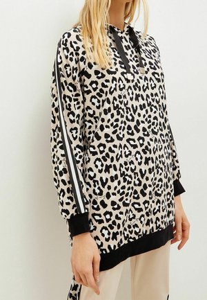 Sweat à capuche imprimé léopard en beige et noir, avec manches longues, capuche à cordon de serrage et accents noirs sur les côtés.
