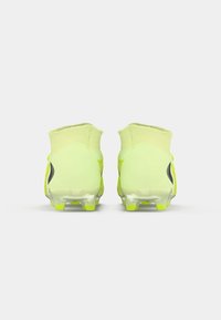 Fényes sárga focisorok, amelyek áramvonalas dizájnnal, texturált felső részel és átlátszó stoplikkal rendelkeznek. Puha gallér és fekete díszítések találhatók az oldalán.