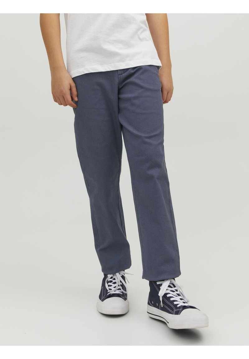 Pantalon en coton bleu marine avec une coupe décontractée, jambes droites et poches latérales, assorti à des baskets blanches et bleues marine avec des lacets blancs.
