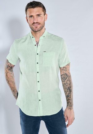 Helles mintgrünes kurzärmliges Hemd aus eine Leinenmischung, mit einem Button-Down-Kragen, schwarzen Knöpfen und einer Brusttasche.
