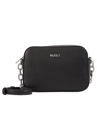 Černá kožená crossbody taška s texturovaným povrchem, stříbrným řetízkovým popruhem a logem značky na přední straně. Obdélníkový tvar s zaoblenými okraji.