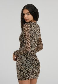 Abito maculato di leopardo con lunghe maniche trasparenti; corpino aderente; tessuto testurizzato; tonalità terrose di marrone e nero; lunghezza al ginocchio.