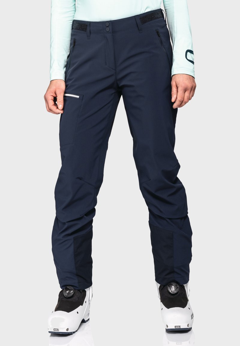 Dunkelblaue Skihosen mit einem schlanken Design, hergestellt aus einem strapazierfähigen Material. Zu den Merkmalen gehören Reißverschlusstaschen und ein verstärkter Unterschenkel.