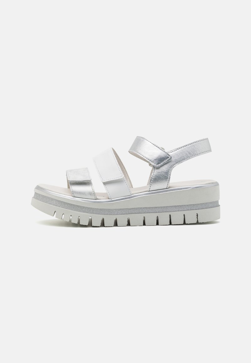 Silberne und weiße Sandalen mit drei verstellbaren Riemen, einer dicken weißen Sohle mit rutschfester Textur und einem metallischen Finish im oberen Bereich.