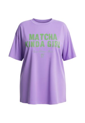 Lavendelkleurig oversized T-shirt met groene tekst "MATCHA KINDA GIRL" en kleinere, cursieve tekst eronder met een klein matcha drankje pictogram.