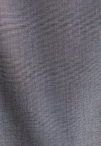 Gros plan sur un tissu gris finement tissé avec un motif en maille fine et des ombres diagonales subtiles.