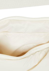 Cream-colored bag interior with smooth fabric lining, featuring a zipper closure and a simple, functional design with no visible patterns.
