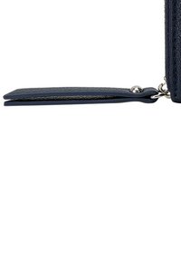 Portefeuille en cuir bleu marine avec une finition texturée, présentant un profil slim et une fermeture à bouton-pression en métal. Comprend une lanière de porte-clés détachable.