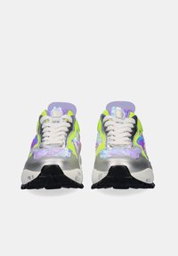 Un par de zapatillas coloridas con cordones blancos, con patrones florales en verde neón, plateado, púrpura y azul, vistas desde el frente sobre un fondo blanco.