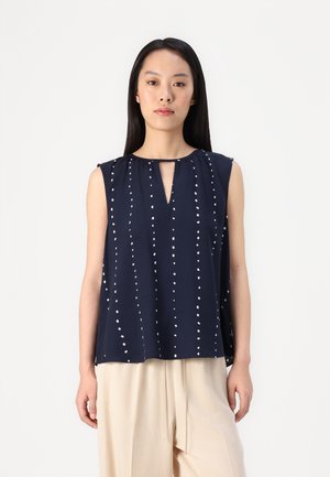 Navy sleeveless top with a keyhole neckline, featuring vertical white dotted patterns and a loose, flowing fit. Soft fabric texture.