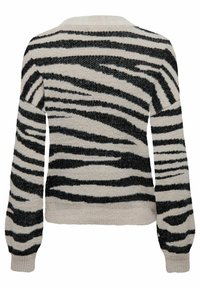 Knit sweater with a cream base and bold black zebra stripes. Features long sleeves and a wide neckline, with textured fabric.