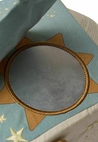 Opbergdoos van stof met een blauwe buitenkant met gouden sterren en een zonontwerp. Binnenin bevindt zich een ronde, metalen, reflecterende spiegel.