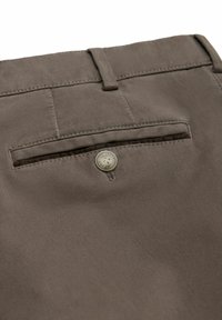 Pantalon en coton marron avec une poche arrière, une fermeture à bouton et des coutures contrastées. Texture lisse avec des lignes épurées.