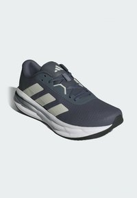 Navy blue athletic shoe with textured mesh upper, reflective light gray accents, padded collar, and thick white midsole.