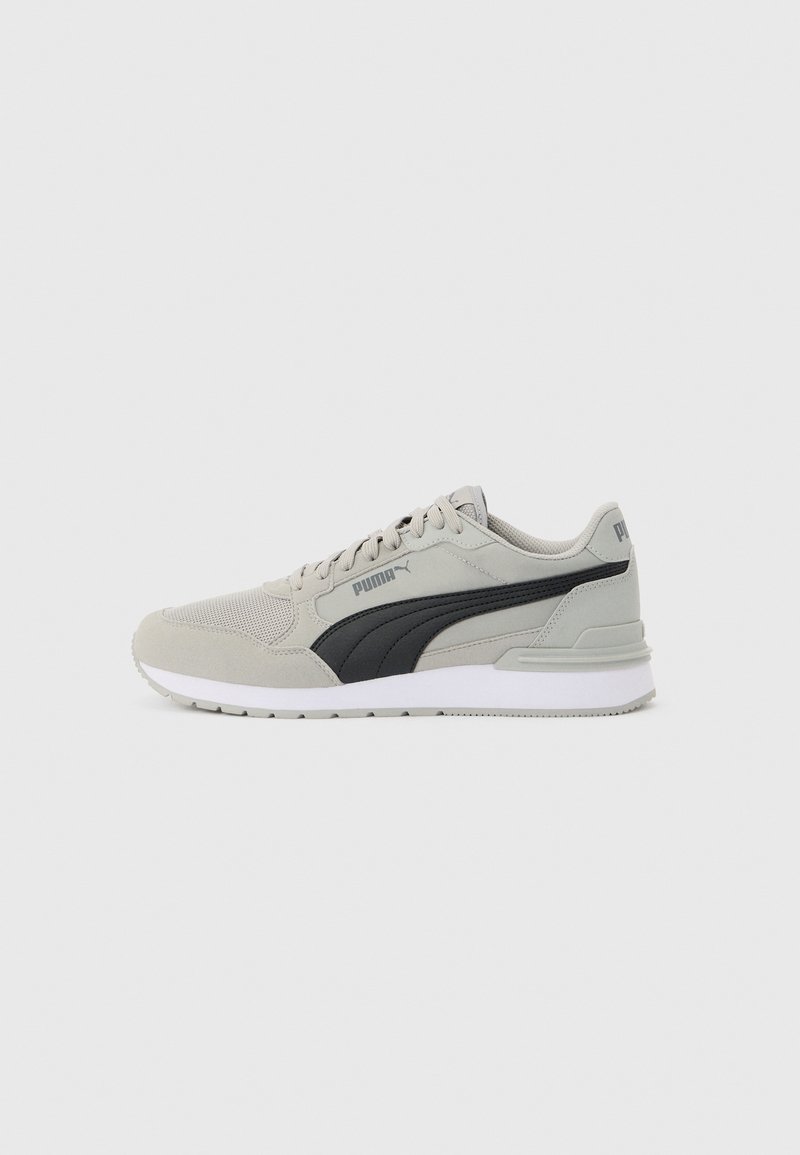 Baskets Puma gris clair avec une bande noire, tige en mesh et daim, semelle blanche et lacets, présentées de profil sur fond blanc.