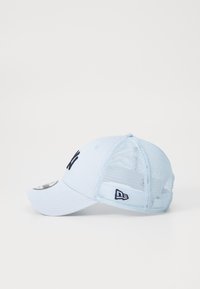 Boné de beisebol azul com uma frente sólida, parte de trás em malha e um logótipo bordado em azul marinho. Apresenta uma aba curva e uma tira ajustável na parte de trás.