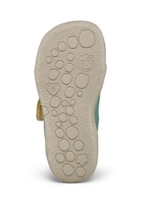 Semelle de chaussure d'enfant avec motifs circulaires texturés, formes de cœur, étoile et visage de singe souriant pour une bonne adhérence et un design ludique.