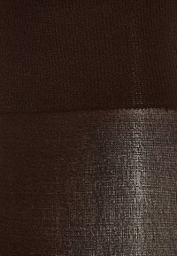 Tessuto marrone texture con una finitura metallica liscia e lucida nella parte inferiore, che contrasta con la sezione superiore opaca.